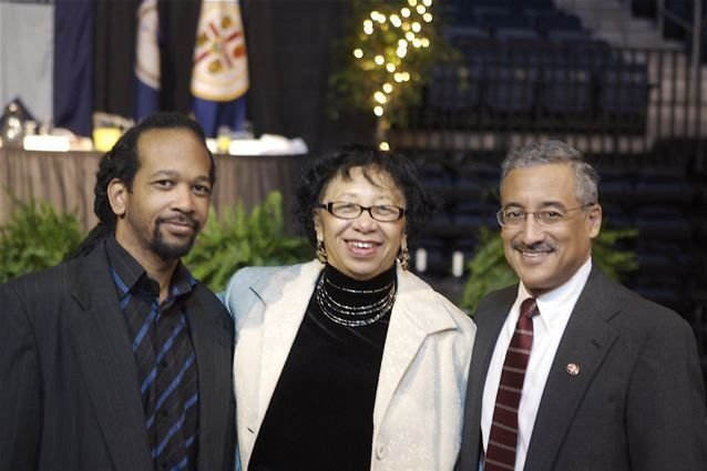 Carolyn between her son Marcus and Congressman Bobby Scott, Virginia flag behind